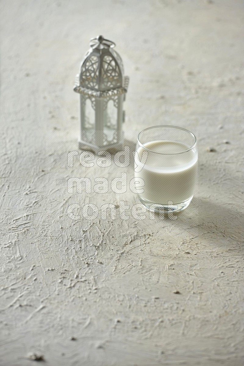 A white lantern with different drinks, dates, nuts, prayer beads and quran on white background
