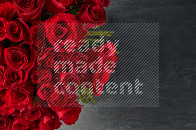 A luxurious bouquet of red roses on black marble background