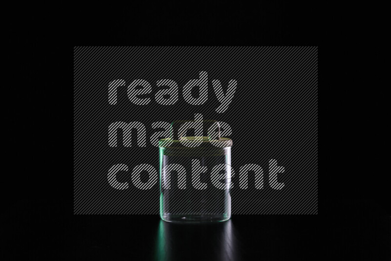 Glassware with rim light in green and white against black background