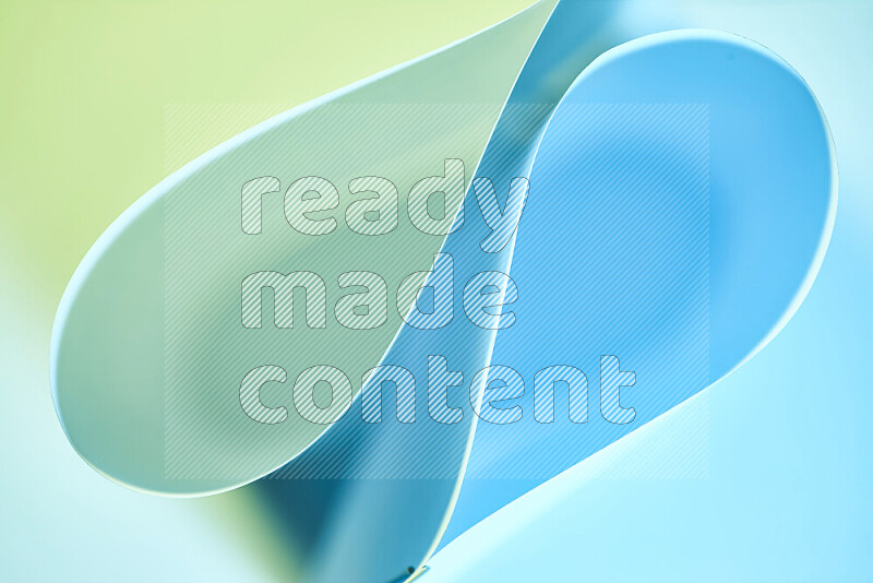 An abstract art of paper folded into smooth curves in green and blue gradients