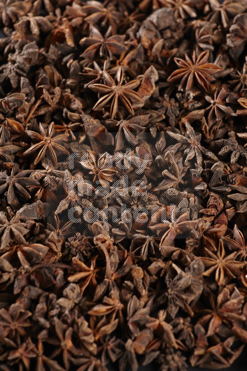 Star Anise herbs fill the frame on black flooring