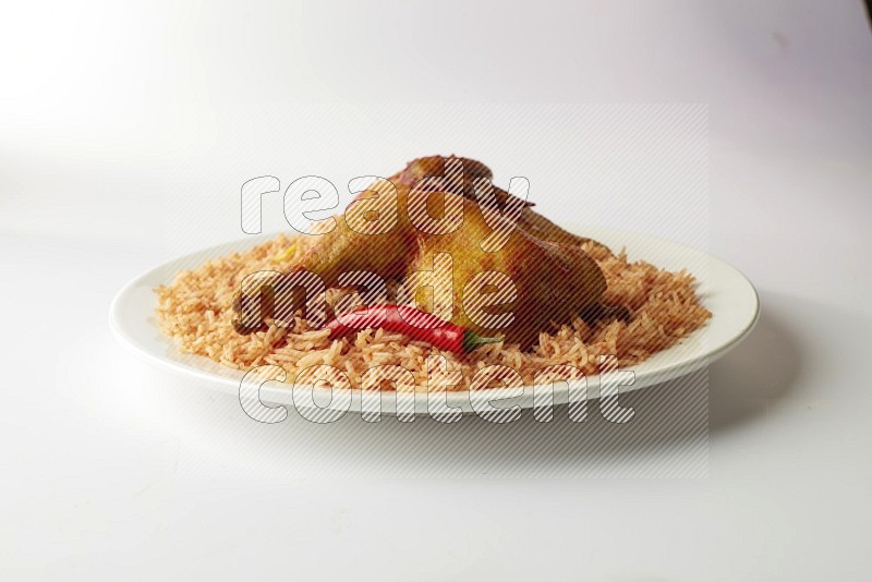 red basmati Rice with kabsa chicken pieces on a white rounded plate direct on white background