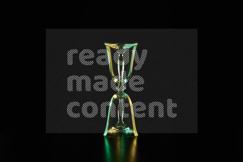 Glassware with rim light in green and yellow against black background