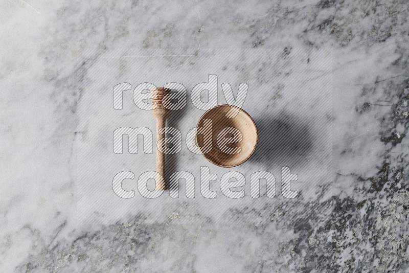 Beige Pottery Bowl with wooden honey handle on the side on grey marble flooring, Top view