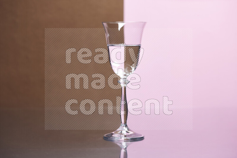 The image features a clear glassware filled with water, set against brown and rose background