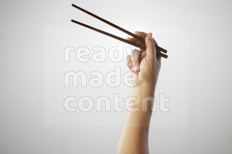 Male Hand Holding Chop Stick on white background