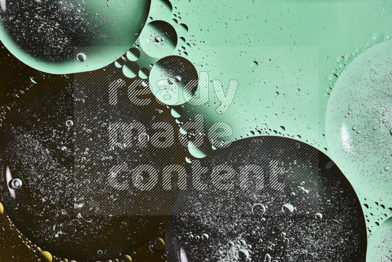 Close-ups of abstract oil bubbles on water surface in shades of black and green