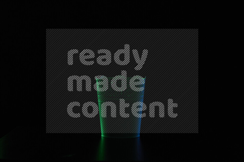 A plant pot with colored rim light against black background