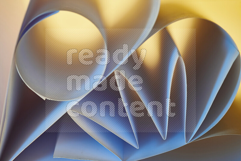 An artistic display of paper folds creating a harmonious blend of geometric shapes, highlighted by soft lighting in blue and warm tones