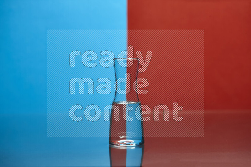 The image features a clear glassware filled with water, set against blue and red background