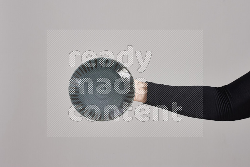 A woman in black abaya holding different pottery essentials in different positions