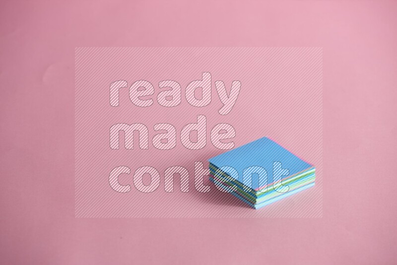 Stacked multicolored sticky notes on rose background