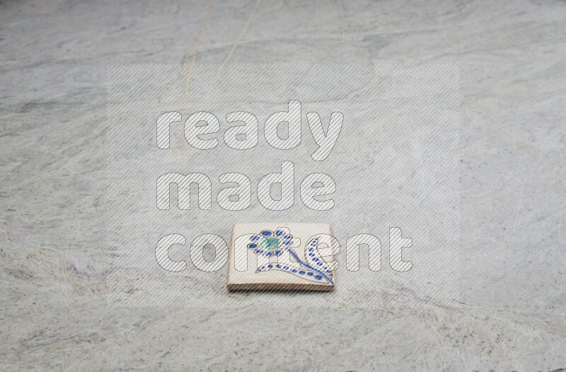 Top view shot of a pottery coaster\ tile on beige marble flooring