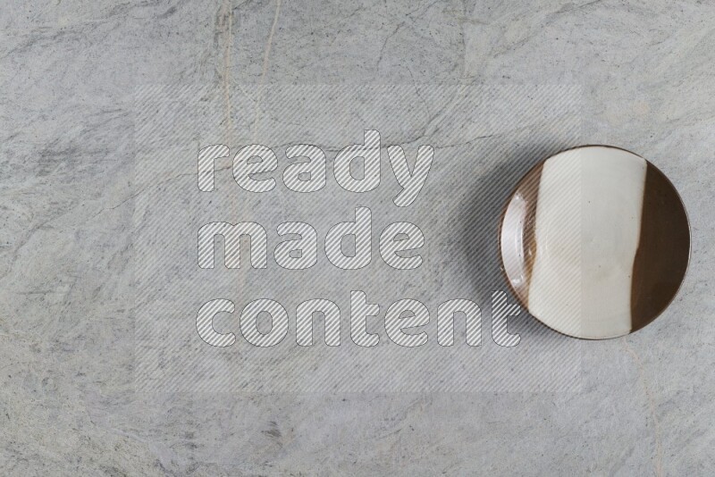 A multicolored pottery plate on grey marble background