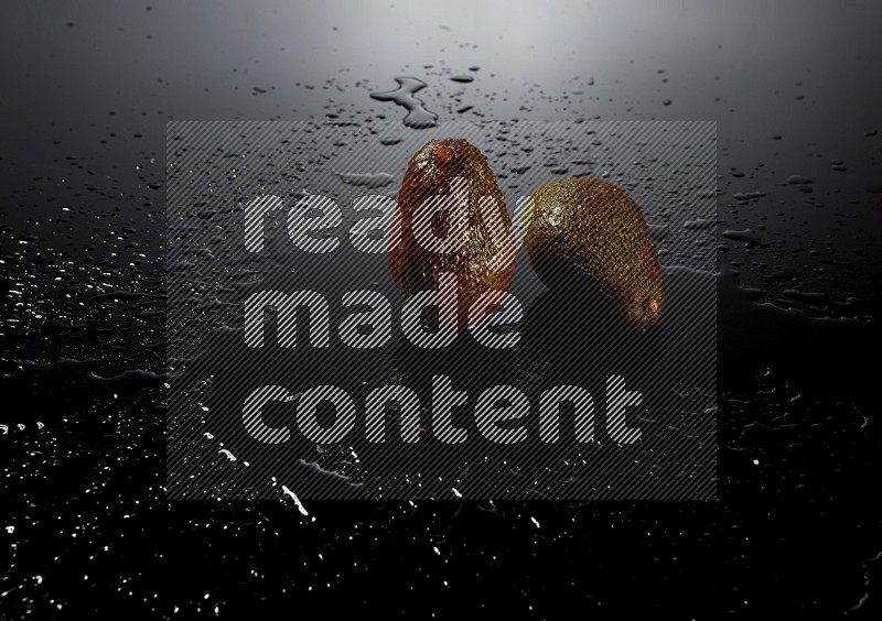 A whole avocado on black background with water drops.
