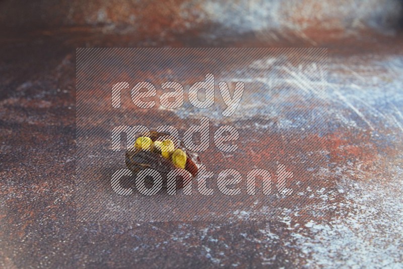 one pistachio stuffed madjoul date on a rustic reddish background