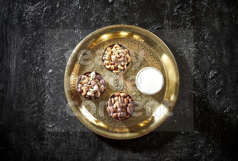 Nuts in metal bowls with sobya on a tray in dark setup