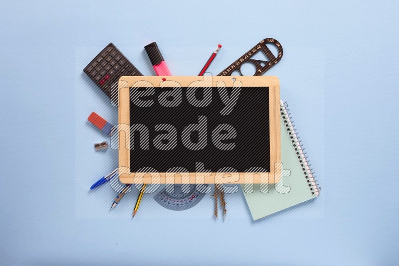 A black board with school supplies on blue background (back to school)
