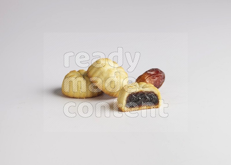 Three Pieces of Maamoul filled with date one of them is cut direct on white background