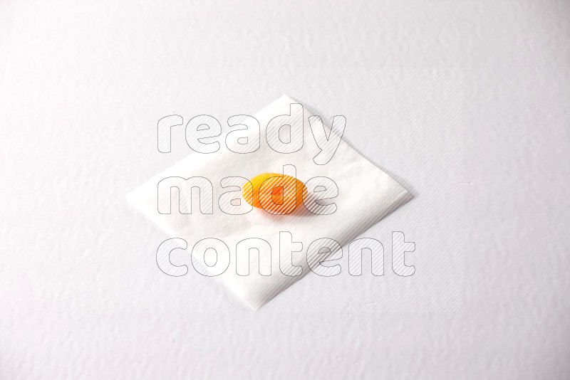 حبة واحدة من المشمش المجفف على قطعة من الورق على خلفية بيضاء
