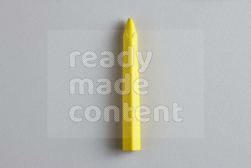 A close-up showing a single wax crayon on grey background