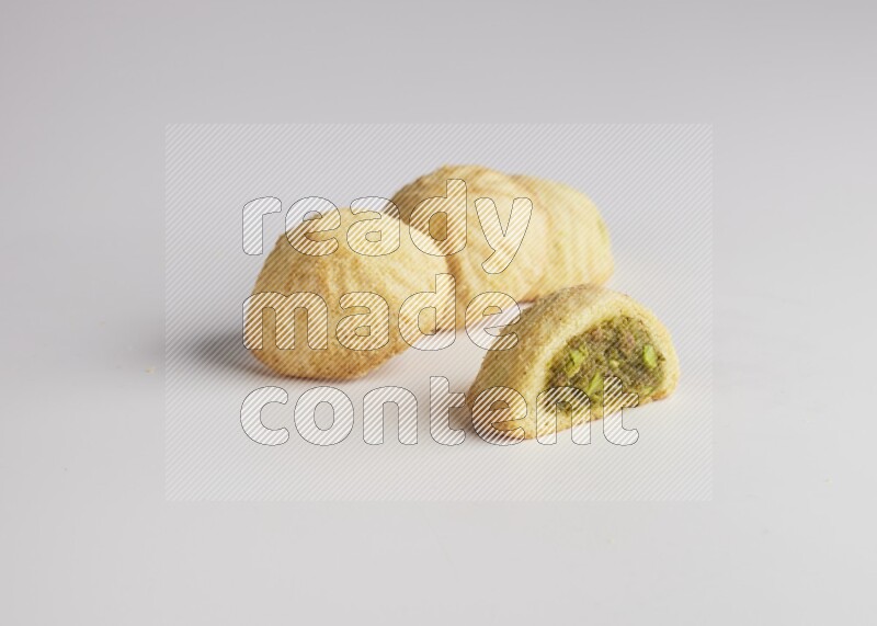 Four Pieces of Maamoul filled with pistachio  paste one of them is cut direct on white background