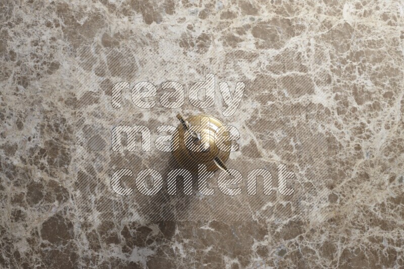 A metal turkish pot for coffee on beige marble background