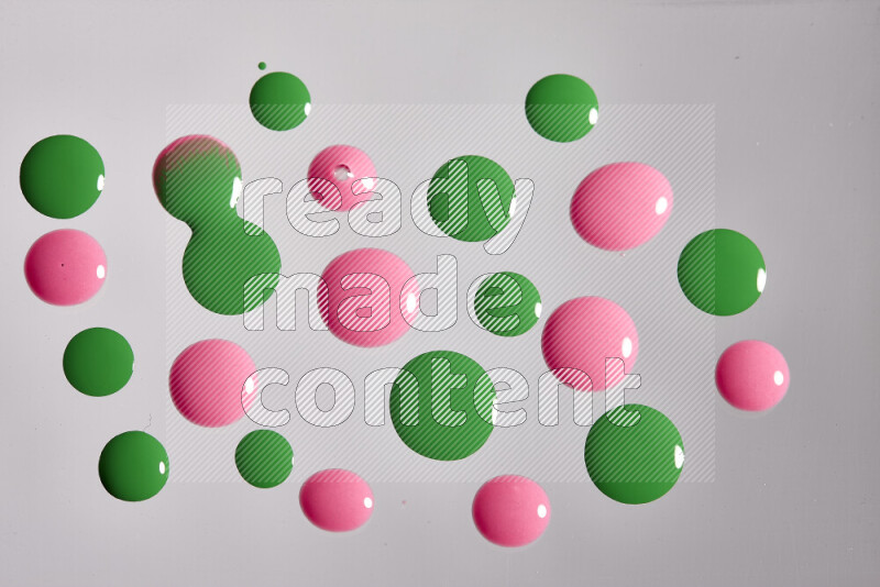 Close-ups of abstract pink and green paint droplets on the surface