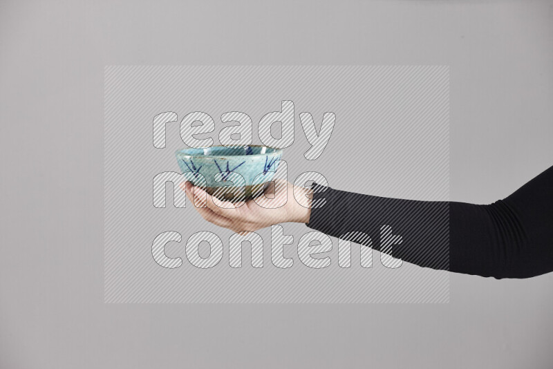 امرأة ترتدي عباءة سوداء تحمل أدوات فخارية مختلفة في أوضاع متعددة