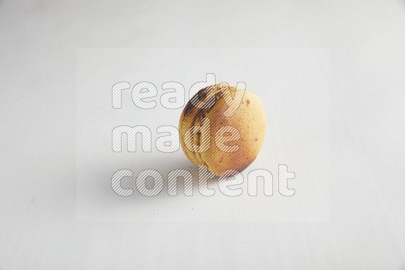 45º Shot of Yellow Crème Brulée macaron on white background