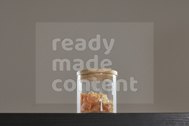 Gum arabic in a glass jar on black background