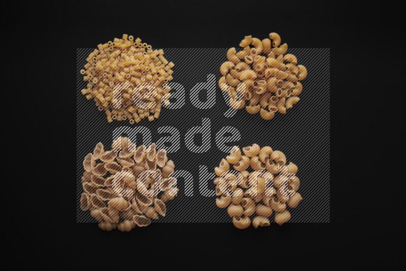Different pasta types in bunches on black background
