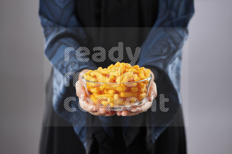 امرأة ترتدي عباءة تحمل أنواع مختلفة من الوجبات الخفيفة في أوضاع متعددة