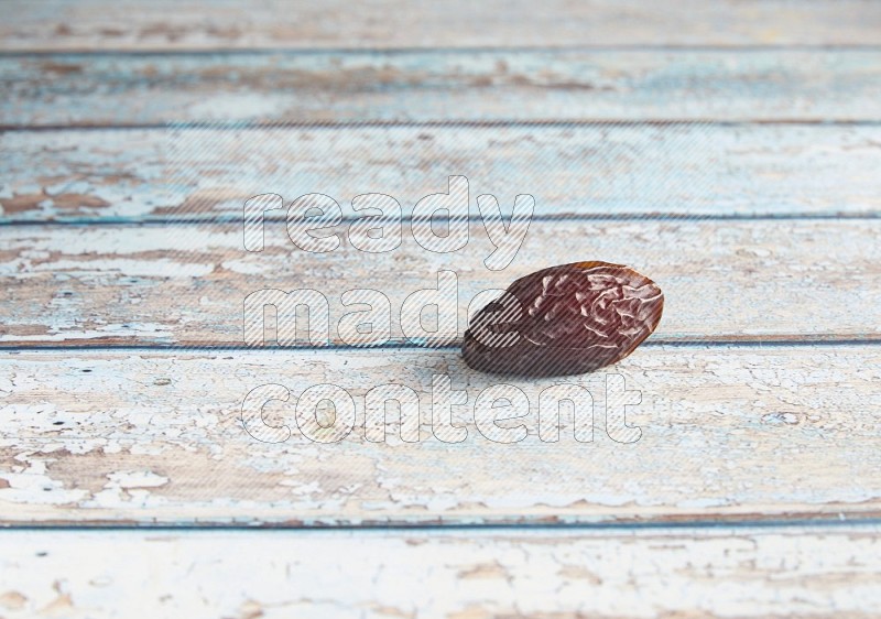 one madjoul date on a light blue wooden background