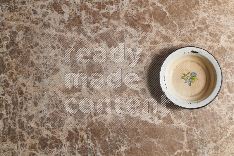 A vintage metal plate on beige marble background