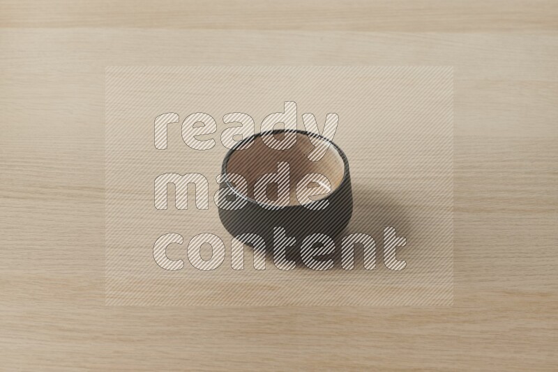A multicolored pottery bowl on light wooden background