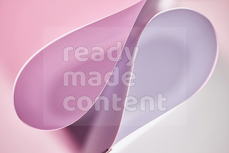 An abstract art of paper folded into smooth curves in white and pink gradients