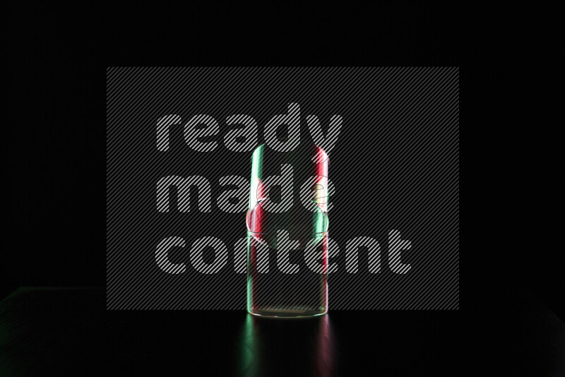 Glassware with rim light in red and green against black background