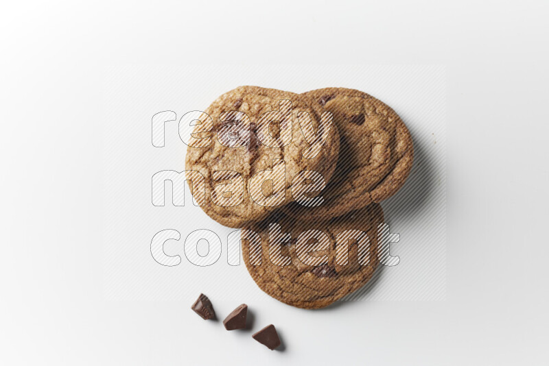 Chocolate chips cookies with chocolate beside it on a white background