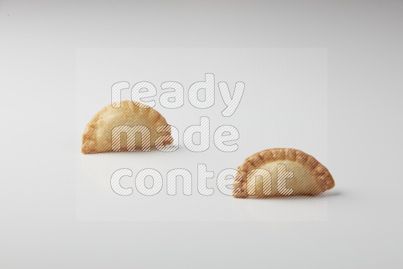 Two fried sambosas on a white background