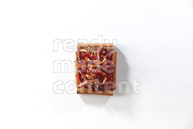 A single square of cinnamon sticks full of chilis on white flooring