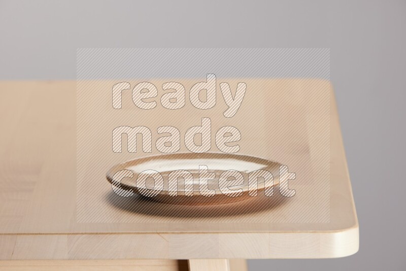 multi-colored pottery Plate on a wooden table edge