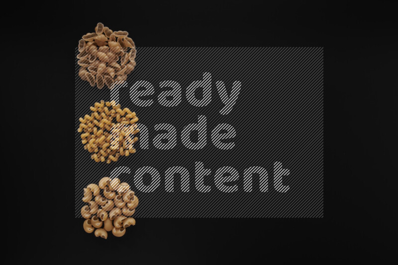 Different pasta types in 3 bunches on black background