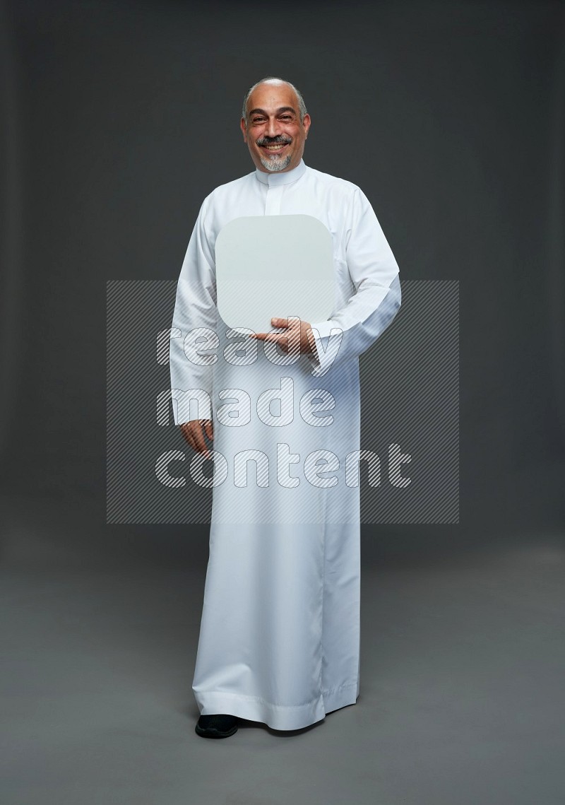 Saudi man without shomag Standing holding social media sing on gray background
