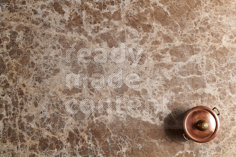 Top View Shot Of A Small Copper Pot On beige Marble Flooring