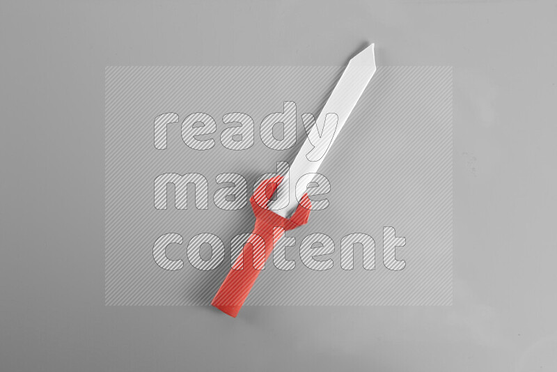 Origami sword on grey background