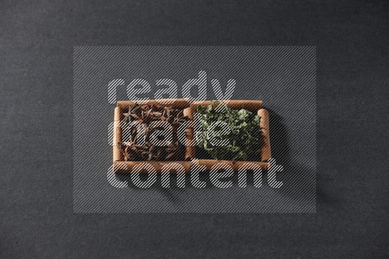 2 squares of cinnamon sticks full of star anise and dried mint leaves on black flooring