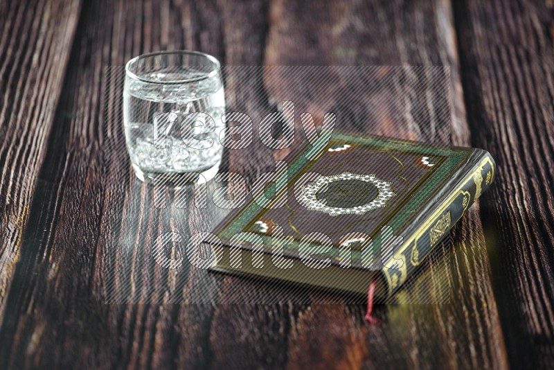 Quran with dates, prayer beads and different drinks on wooden background