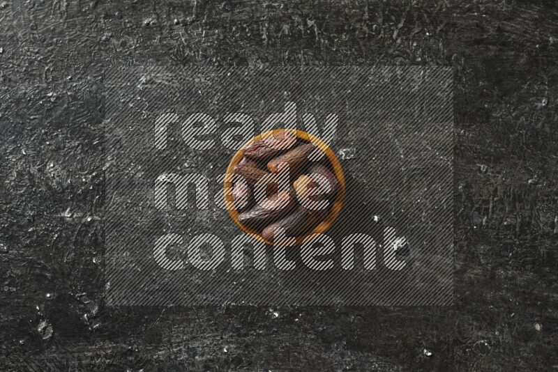 تمر في أطباق خشبية علي خلفية سوداء