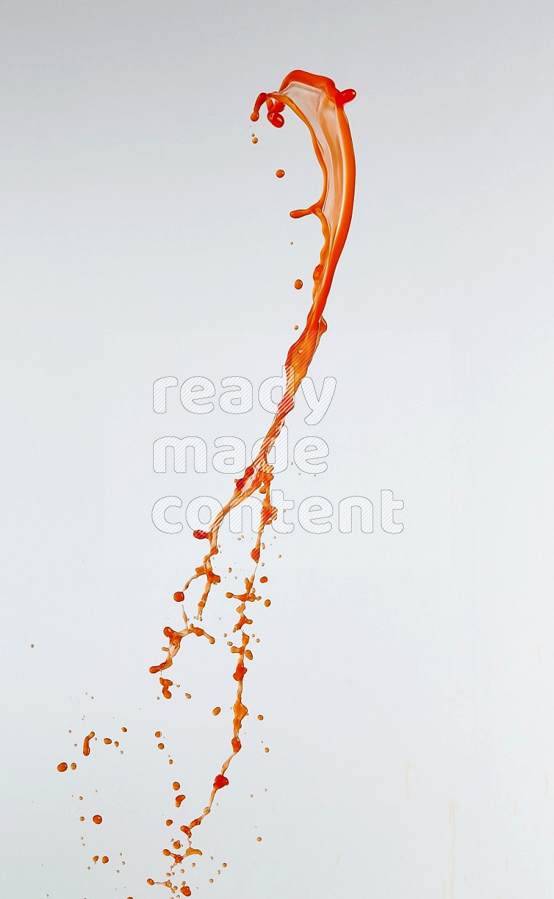 Orange liquid splash and drops on white background